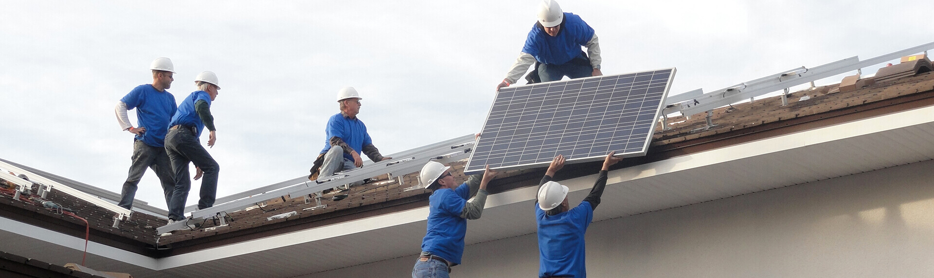 Мужчины устанавливают солнечные батареи на крыше